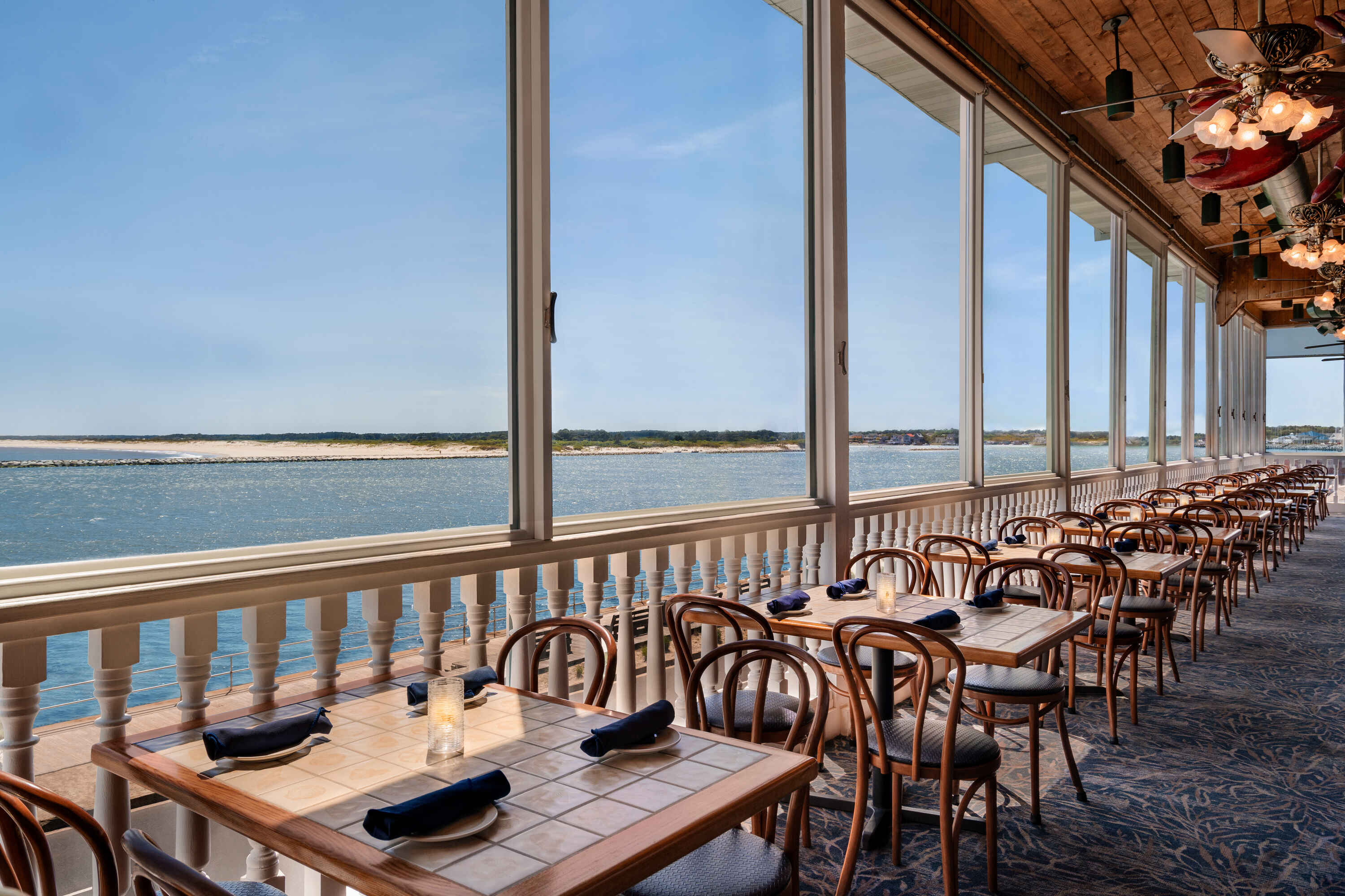 A restaurant dining area with large windows overlooking the water.