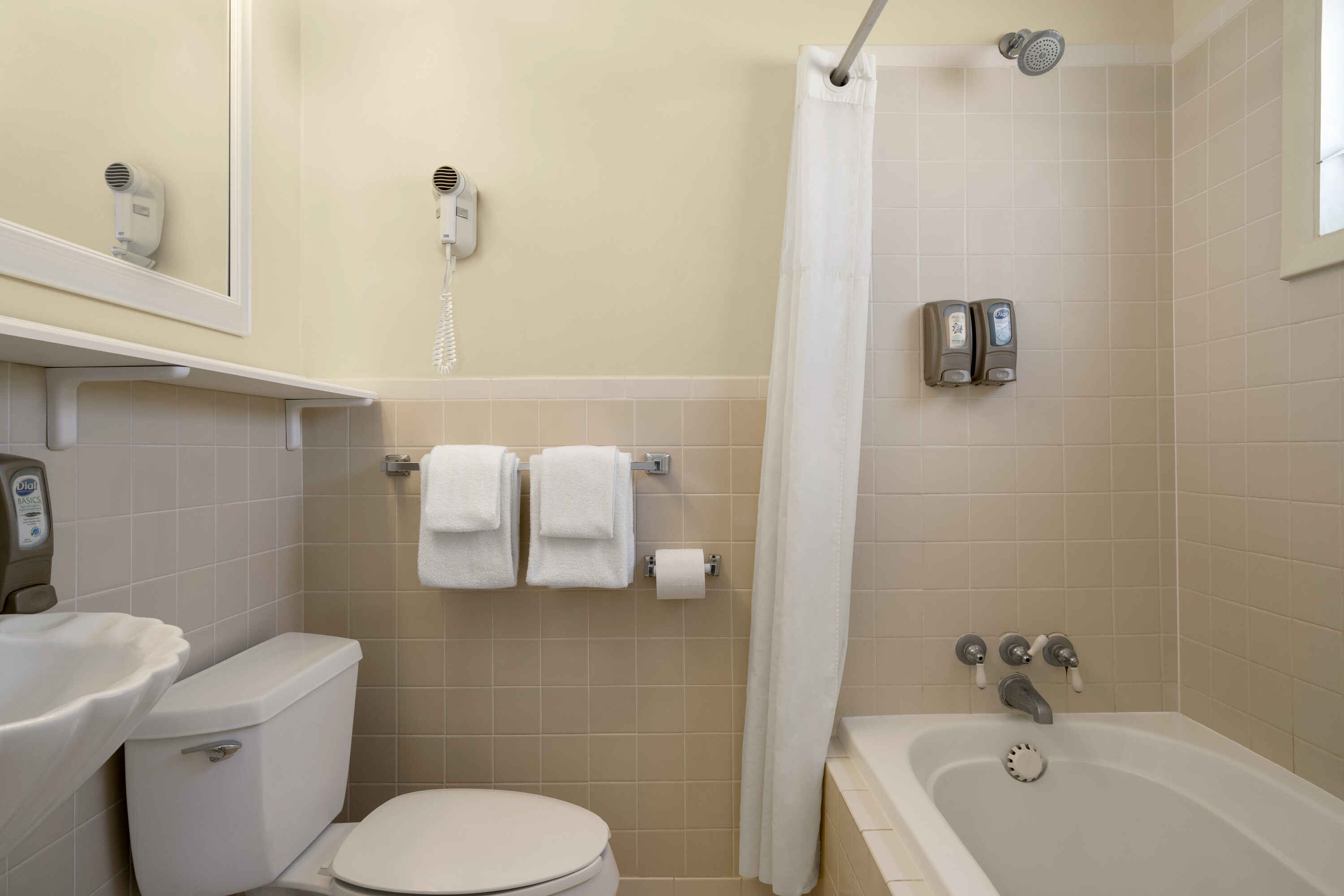 A clean bathroom with a toilet, sink, bathtub, and shower.