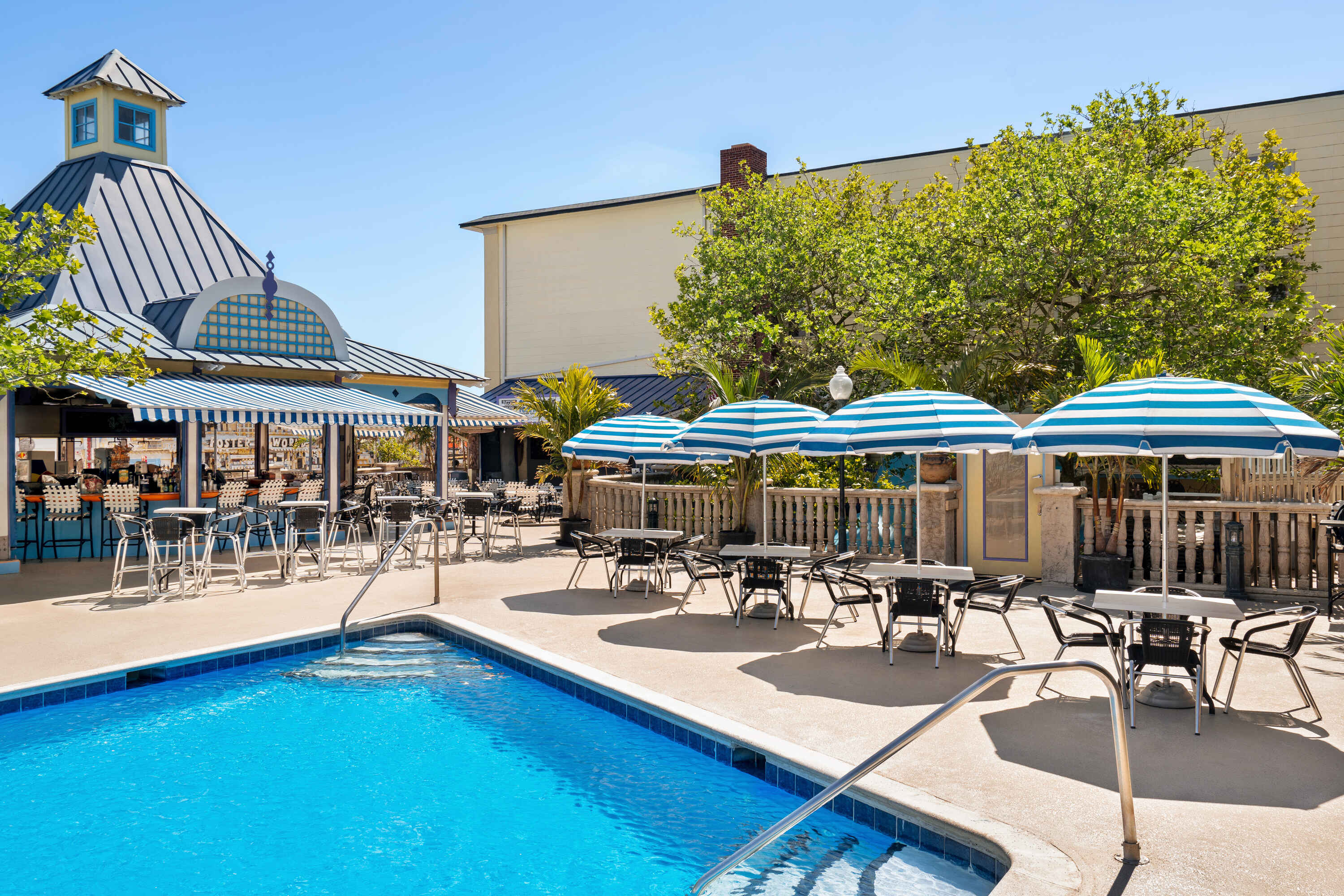 A swimming pool with a bar and outdoor seating area