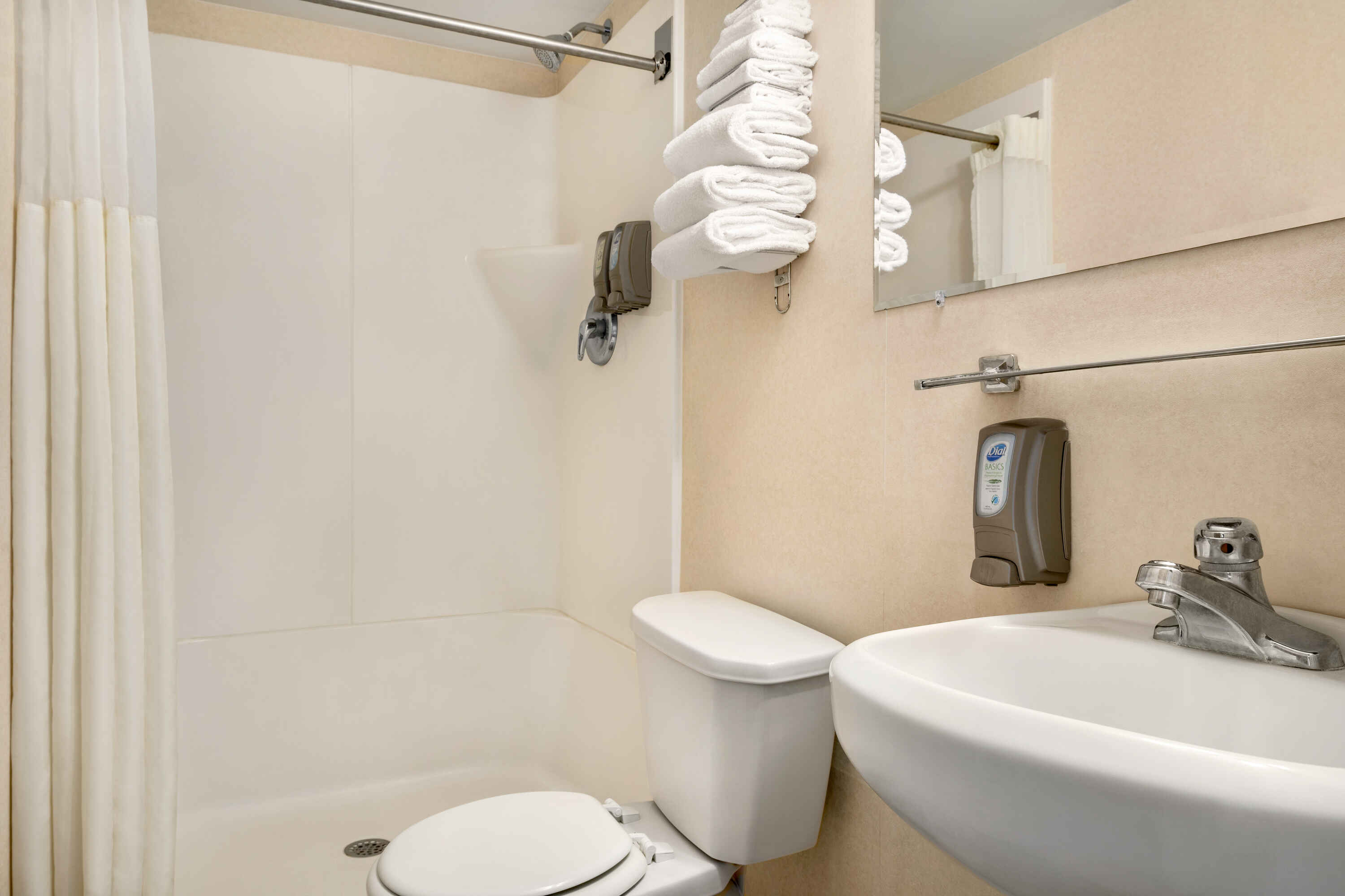 A clean bathroom with a toilet, sink, and shower